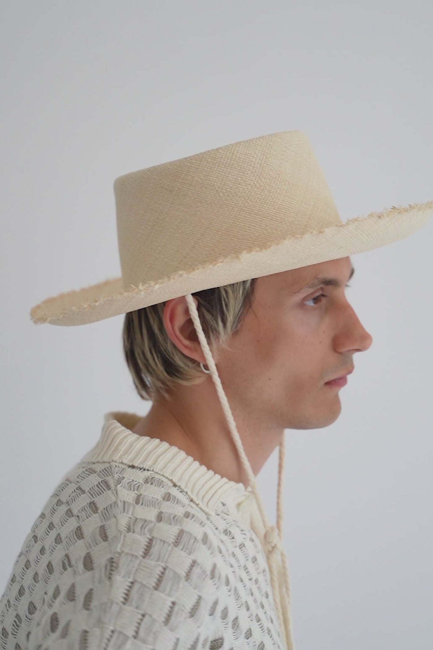 Unisex natural straw bolero style hat with a wide frayed brim, telescope crown and off-white rope chin strap and yellow beads, handcrafted by SoonNoon in Stockholm