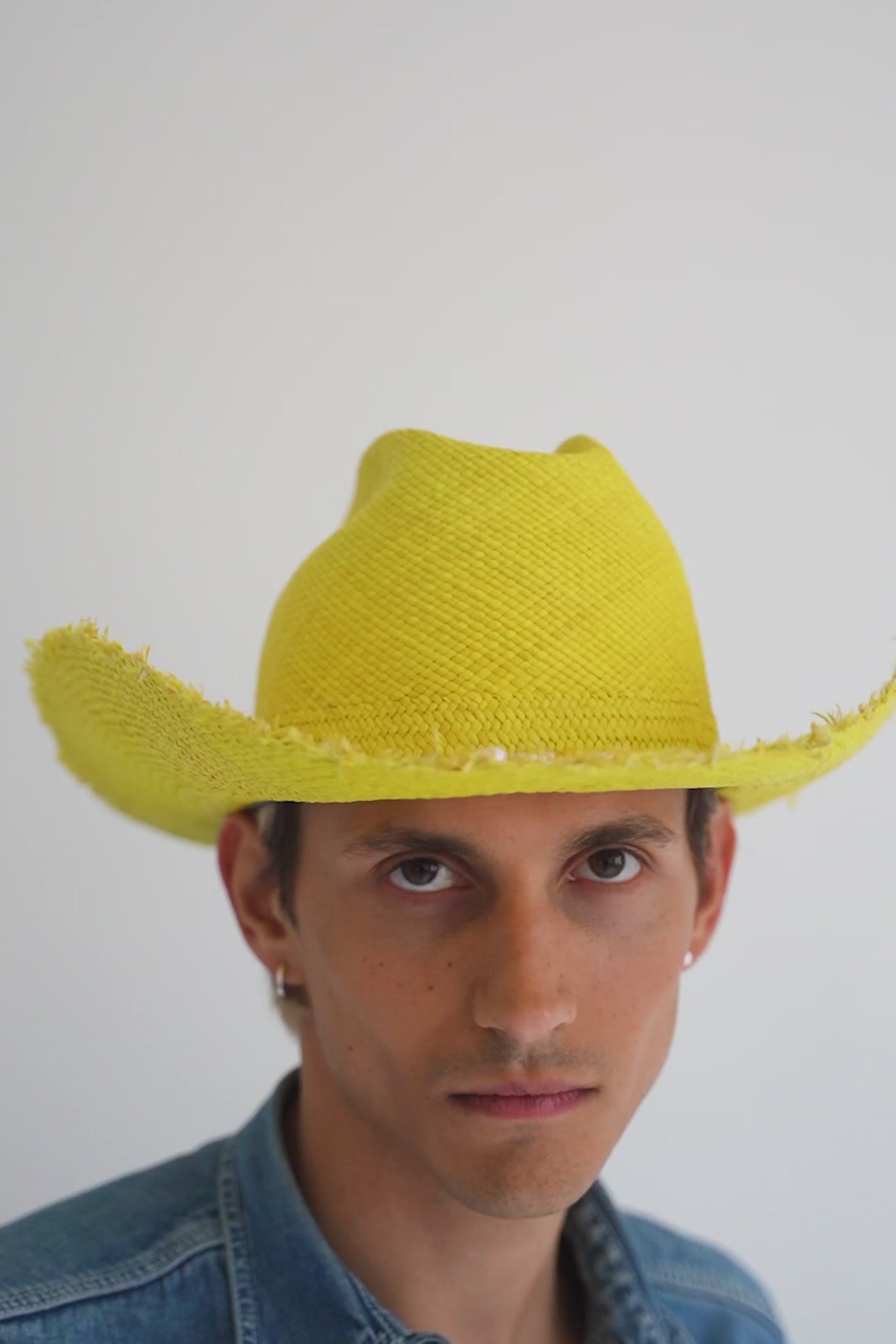 Yellow cowboy straw hat with a wide, flanged brim, frayed edges, and center crease. Seed beads and saltwater pearls detail. Unisex hat style in various sizes and colors. We ship worldwide. Shop now. Each SoonNoon hat is handmade with unique character in Stockholm, Sweden.