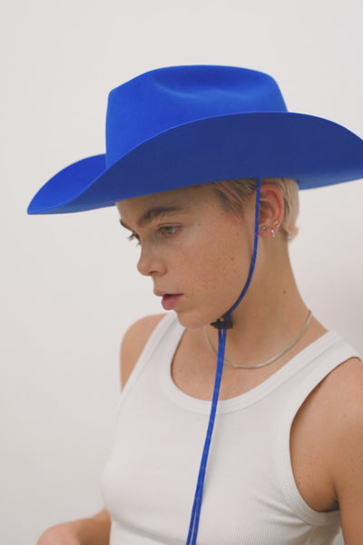 Unisex blue fur felt cowboy hat with a wide brim and center crease. Reflective paracord chin strap detail in blue, handcrafted by SoonNoon in Stockholm